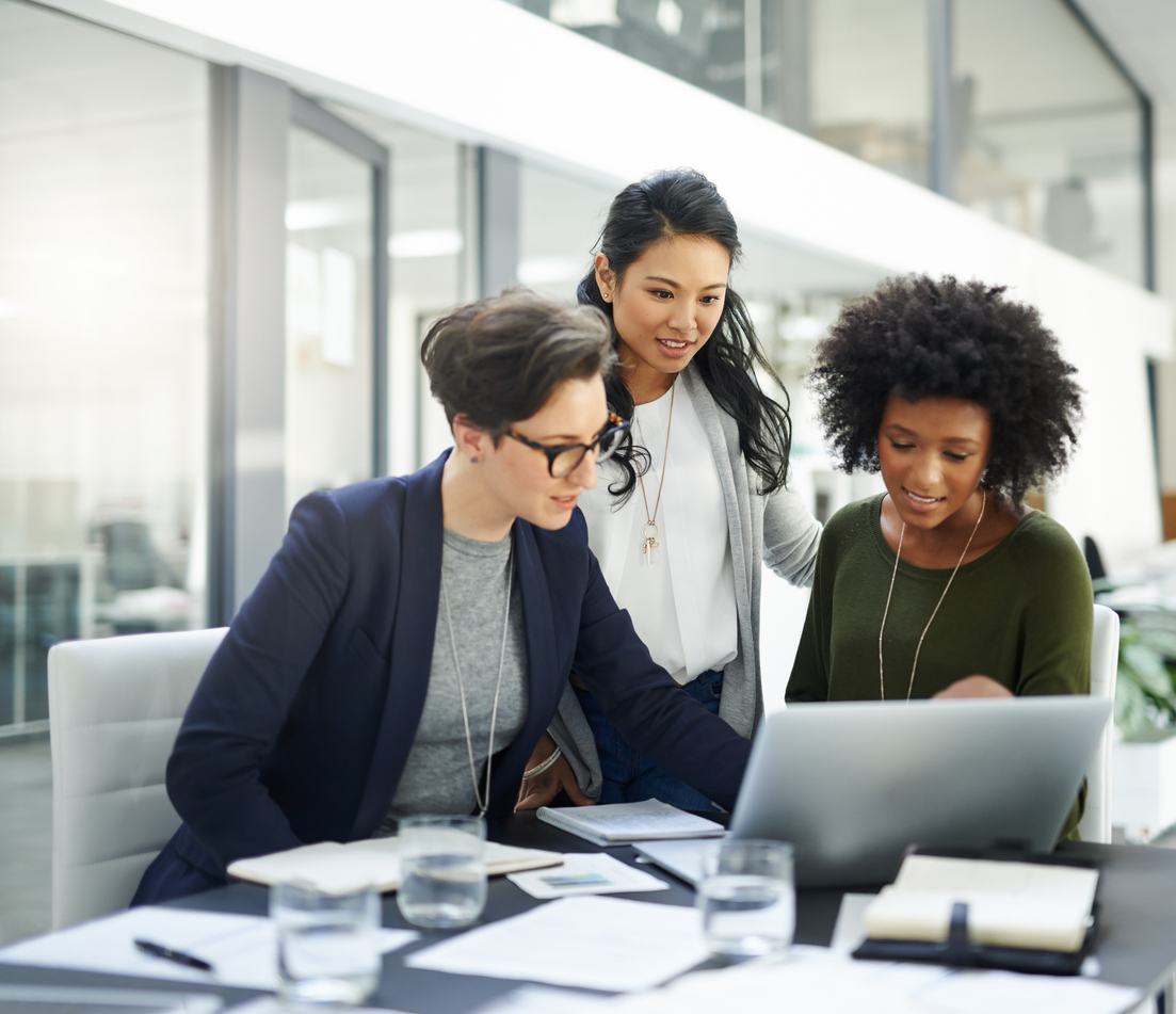 Shot of a group of businesswomen using a laptop during a meeting at work